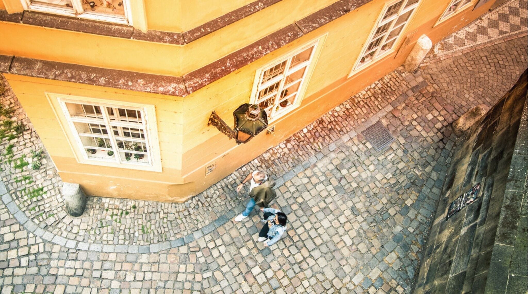 Um casal caminha pela esquina de uma rua estreita na Cidade Velha (Staré Město), um tesouro escondido de Praga. Longa exposição..