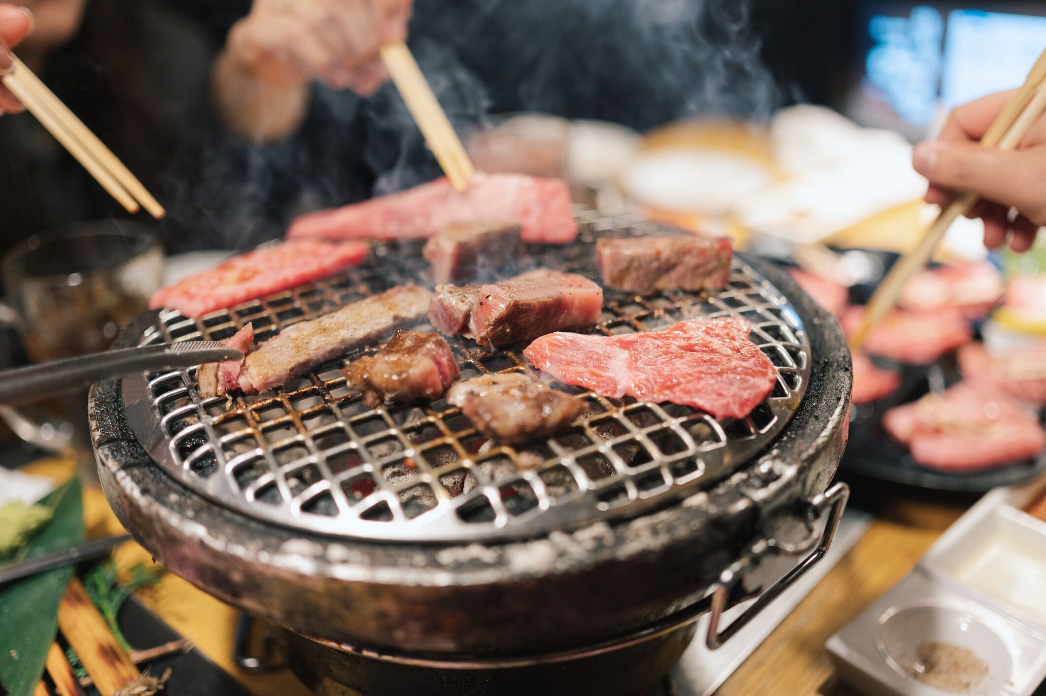 Yakiniku with hands holding chopsticks