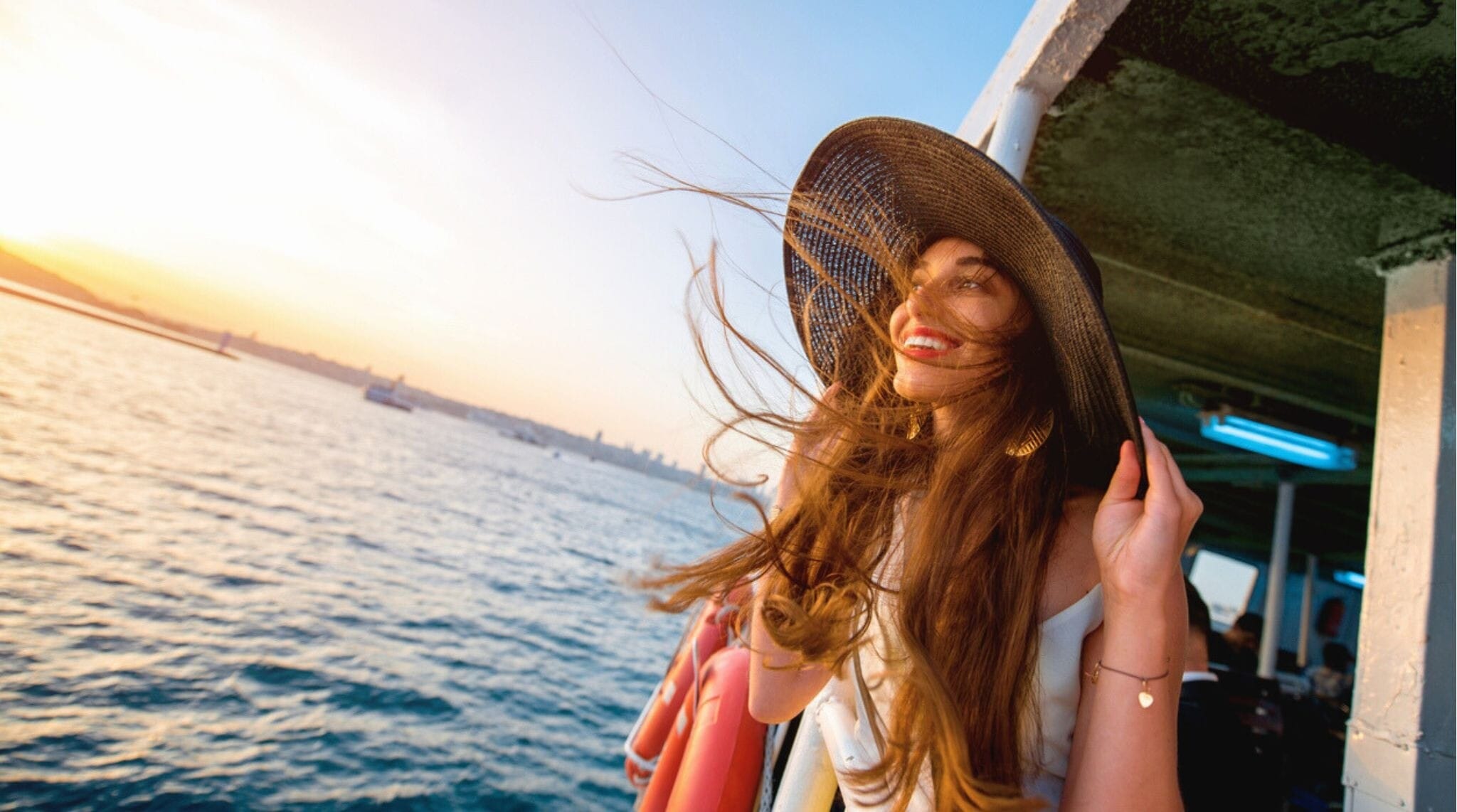 Mulher feliz apreciando a vista a bordo de uma balsa cruzando o Bósforo, em Istambul.