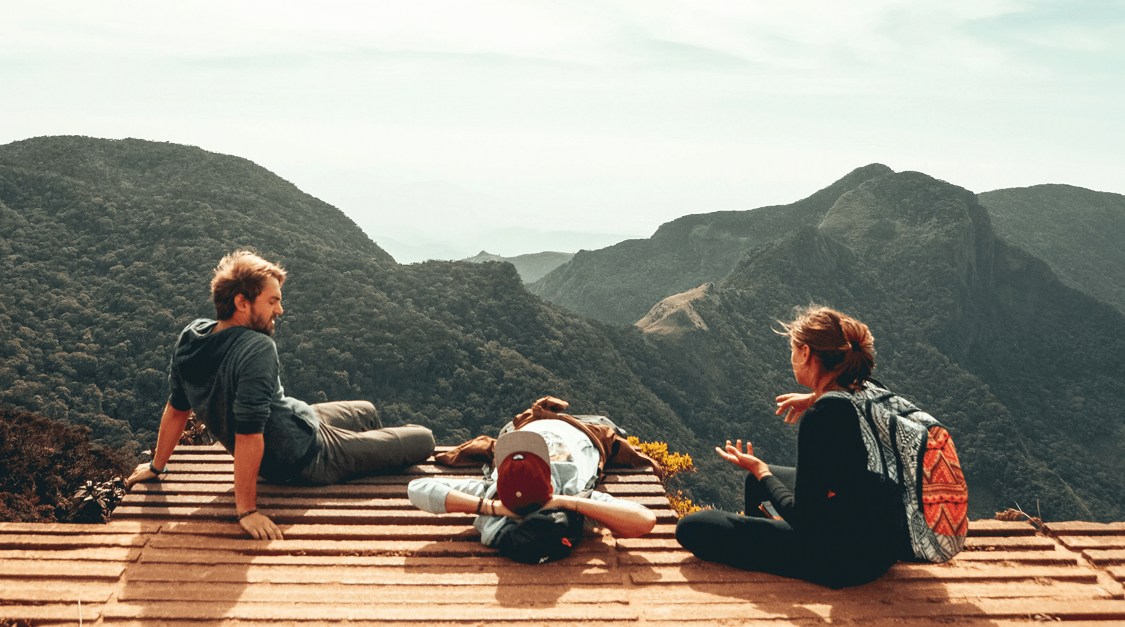 friends sitting at mountain viewpoint