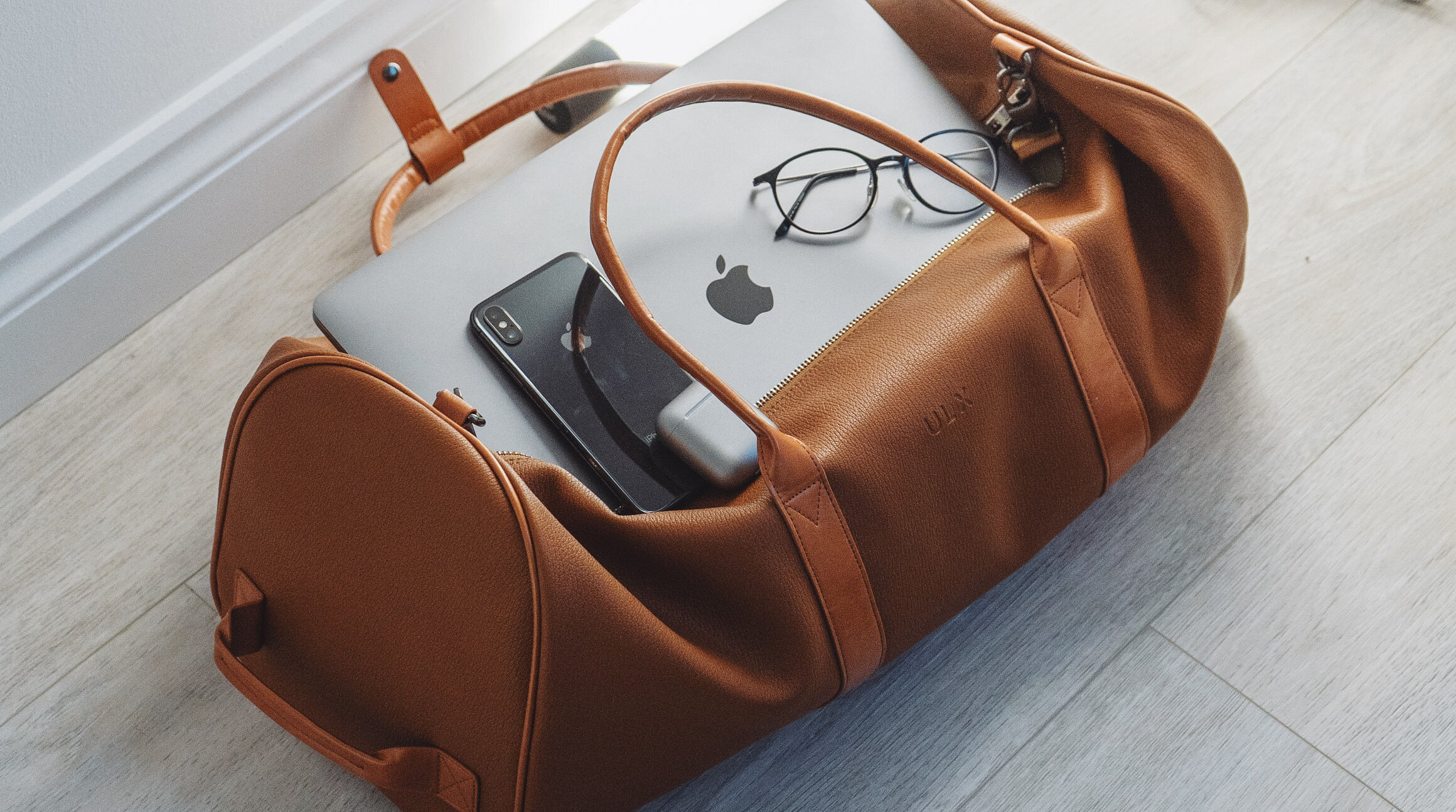 duffel bag with a smartphone and a laptop sitting inside it