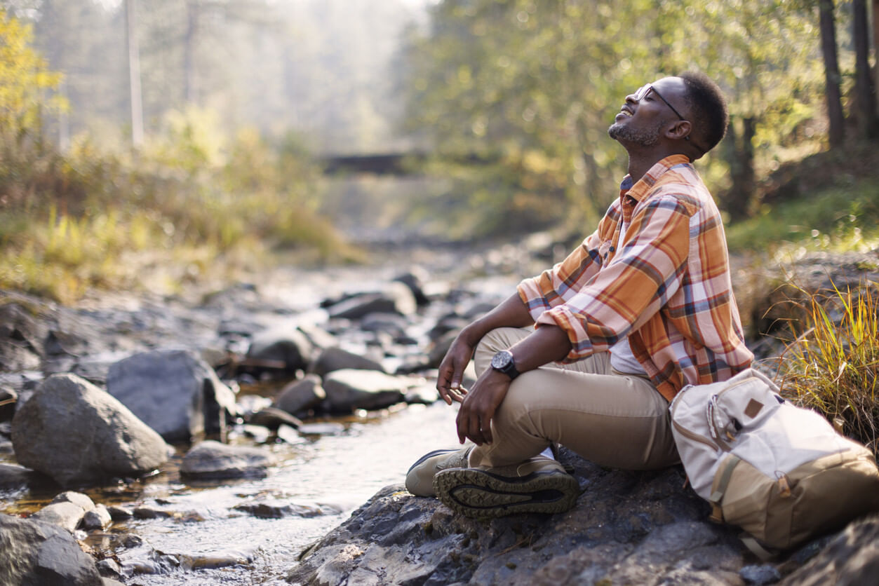 Mann sitzt in der Natur