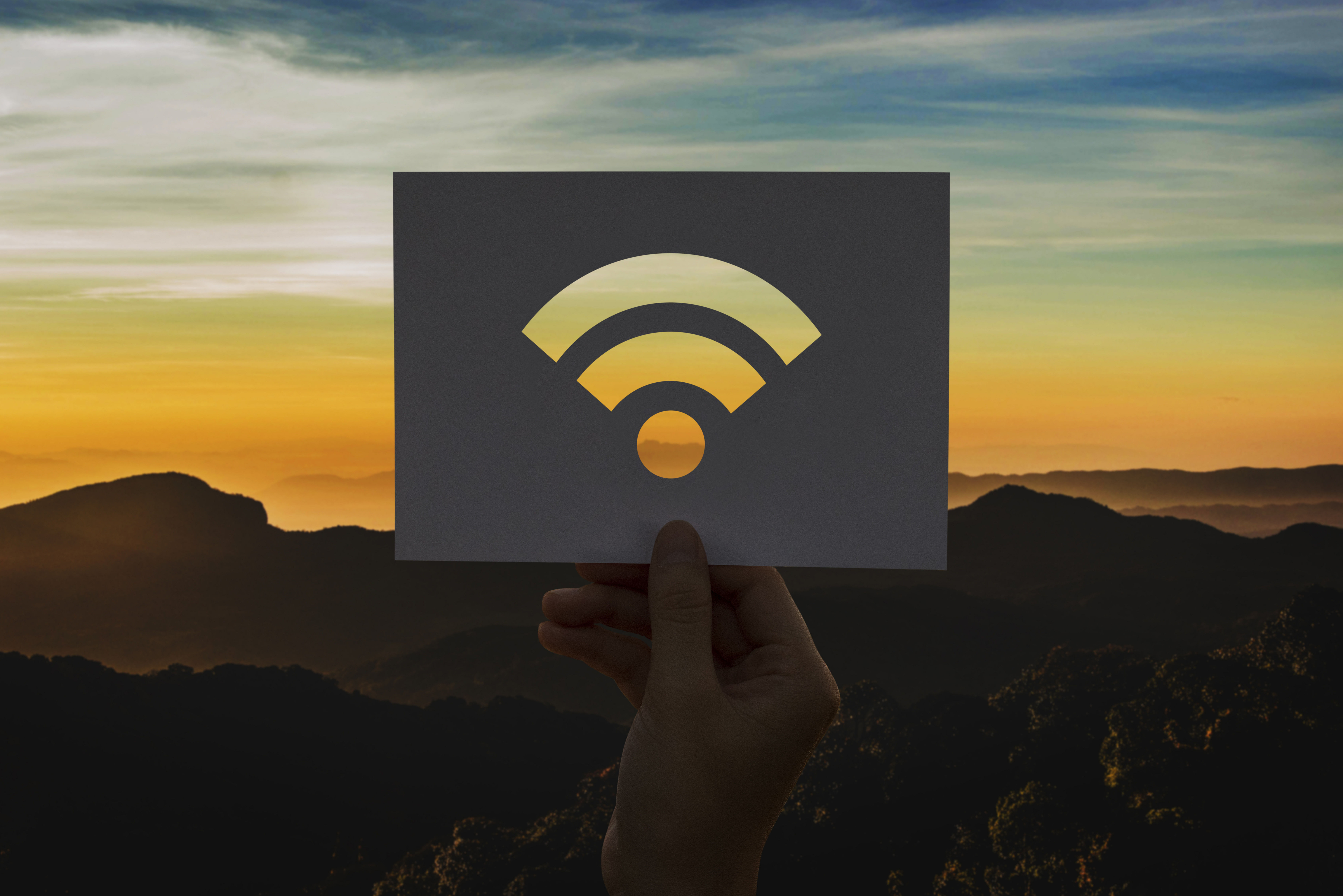 Cutout of Wi-Fi signal held in front a scenic mountain range