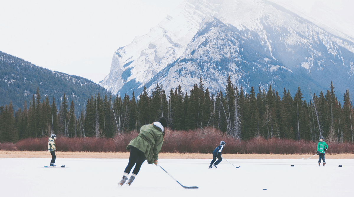 People playing hockey on a lake in Banff, Canada