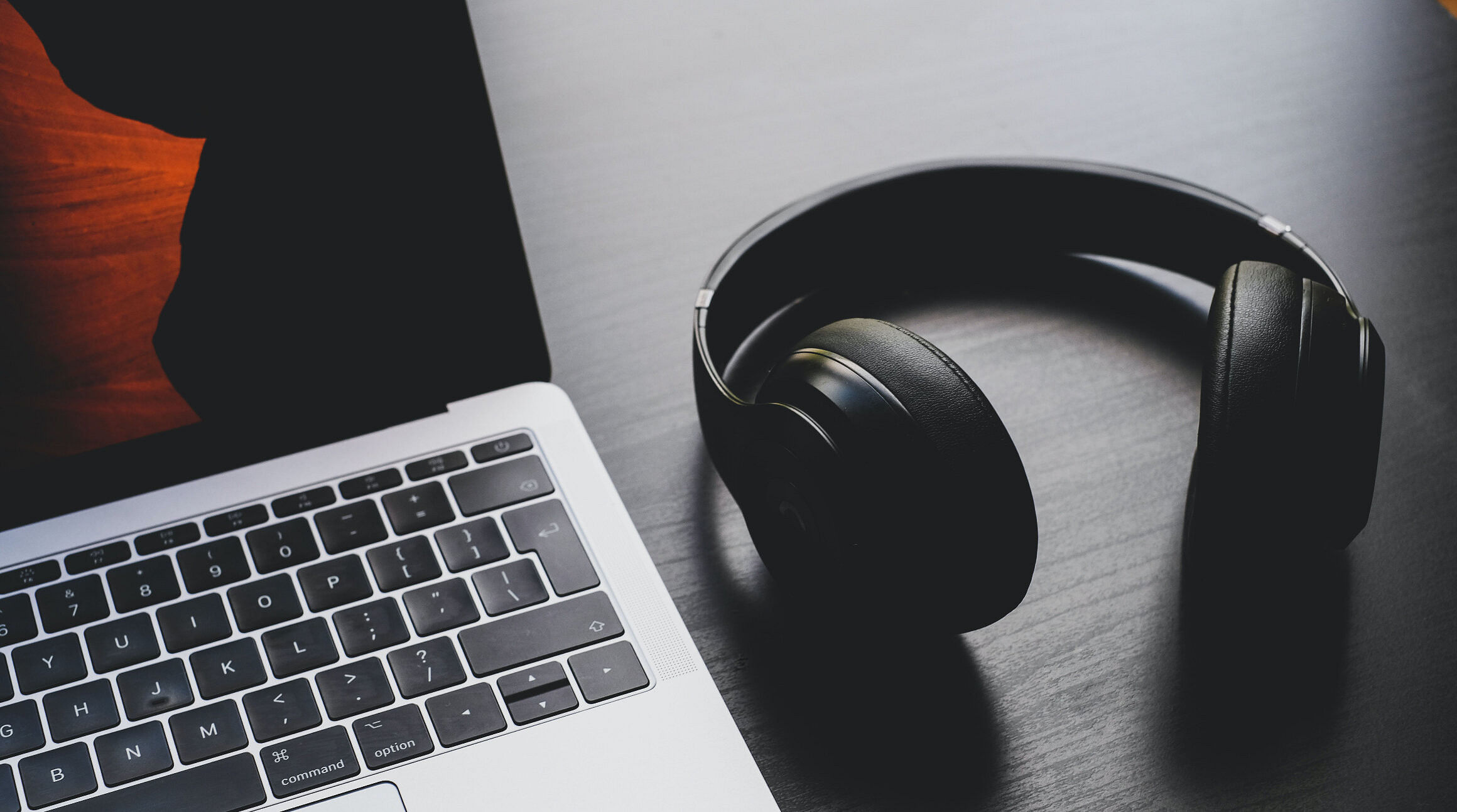 wireless headphones beside a laptop