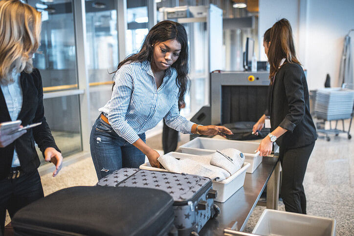 Woman placing belongings in tray at airport security