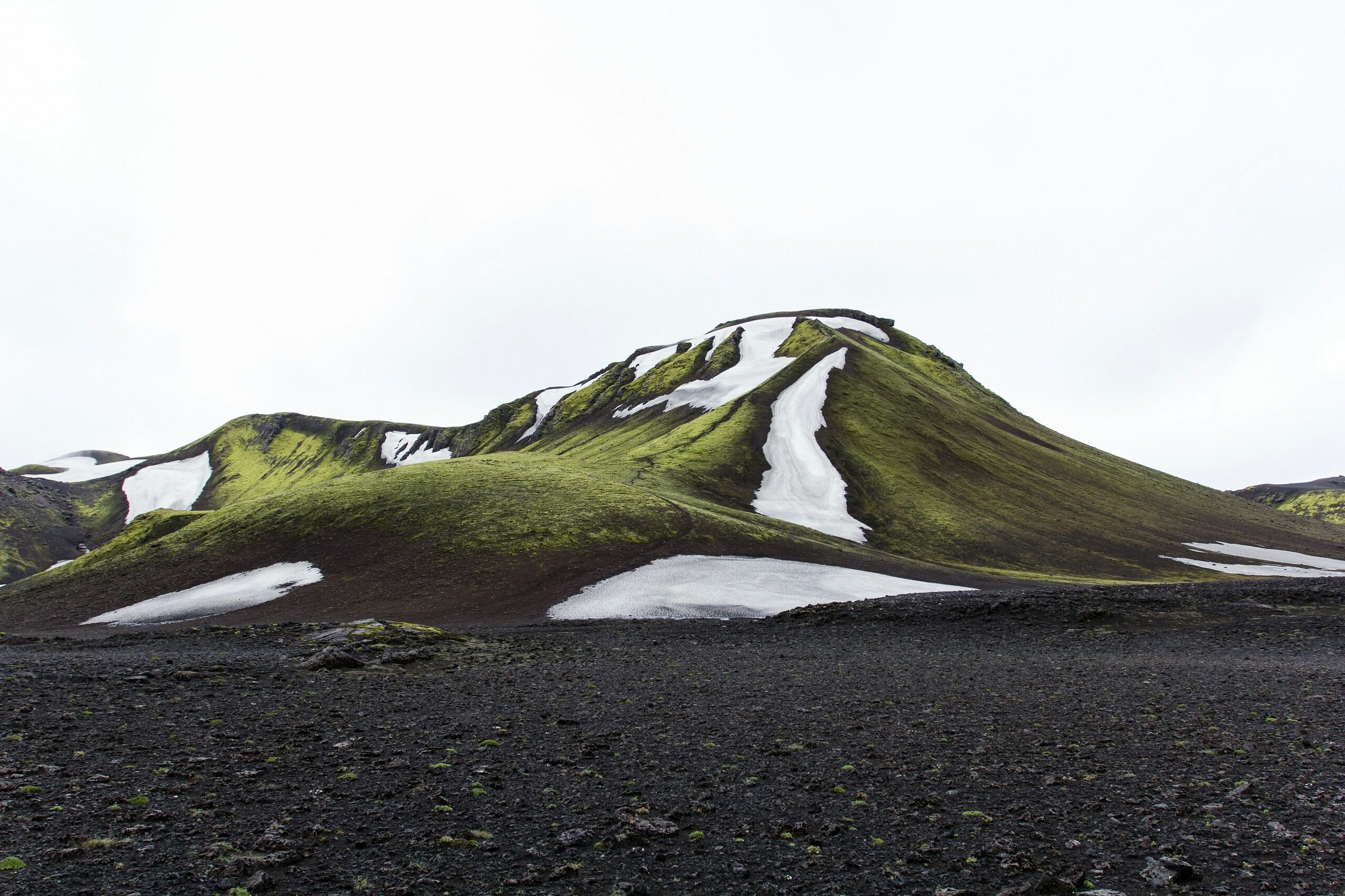 Green mountain peak with snow in Iceland