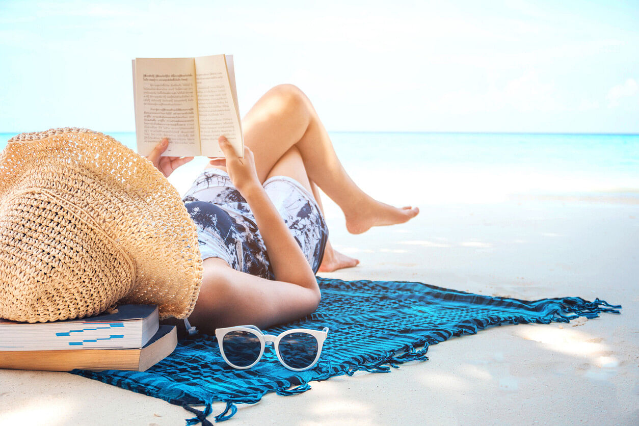 Frau am Strand mit Buch