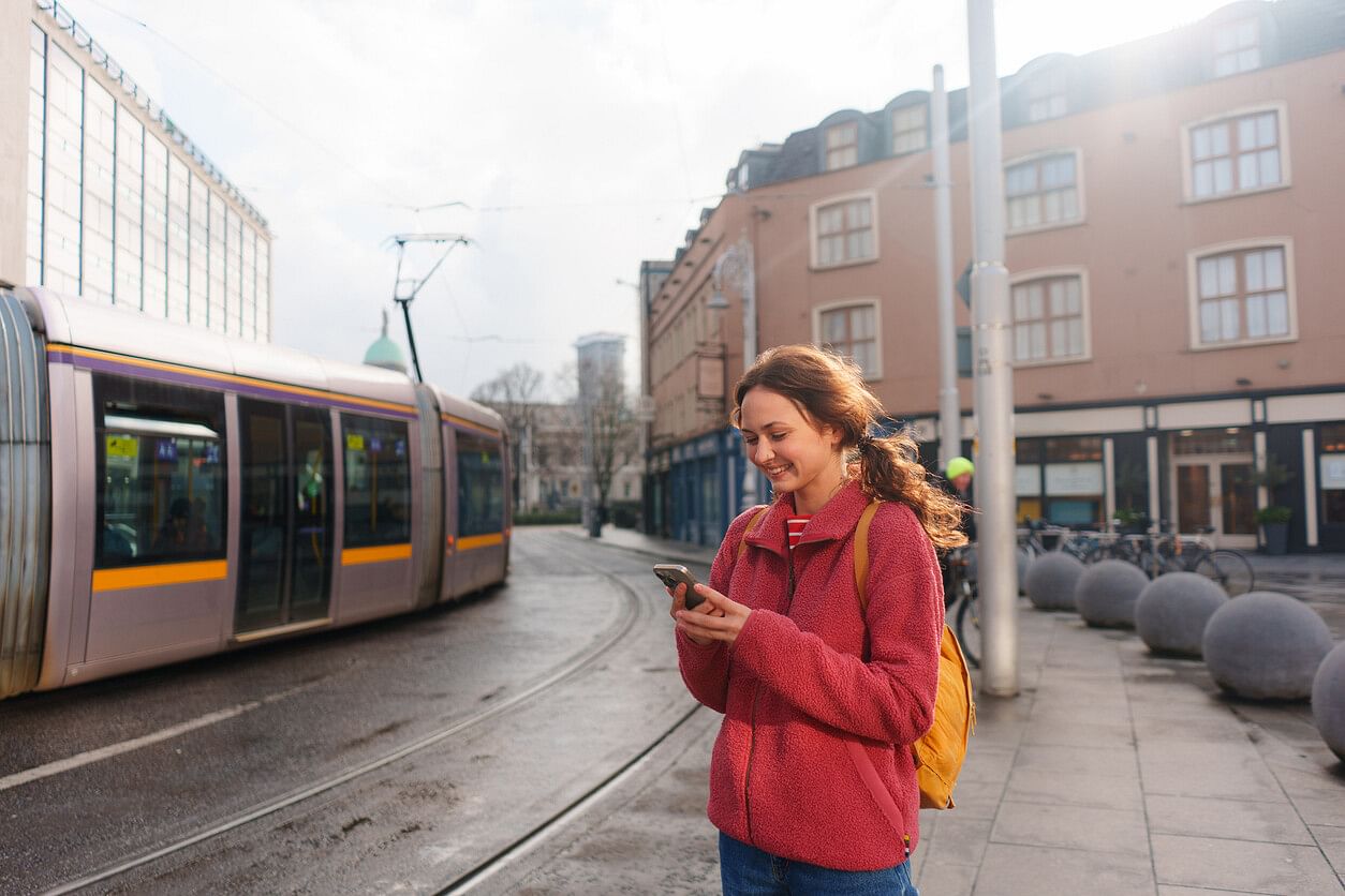 A woman on her phone waiting for the tram in Dublin, Ireland